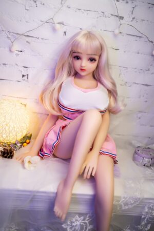 Miniature sex doll wearing a pink pleated skirt